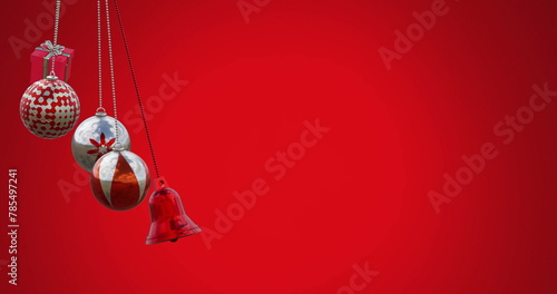 Image of gift box, bell and baubles swinging against red background