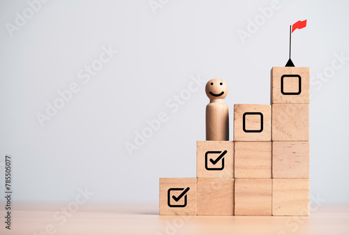 Miniature figure smile and standing on second step with winner flag on the top of step for progress and achieve project business target and goal concept. © Dilok