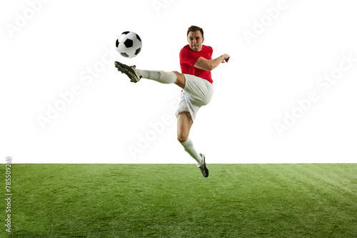 Motivated and competitive male football player hitting ball in jump, during training session of stadium isolated on white background. Concept of professional sport, game, competition, tournament © master1305