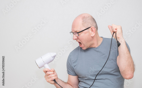 Bald Caucasian man, 50 years old, wearing glasses, uses a hair dryer, pretends to sing,