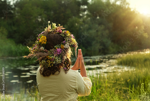 girl in flower wreath outdoor, natural sunny background. rear view. Floral crown, symbol of summer solstice. ceremony for Midsummer, wiccan Litha sabbat. pagan folk holiday Ivan Kupala photo