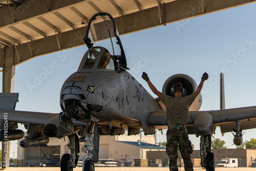 A man is standing next to a fighter jet photo