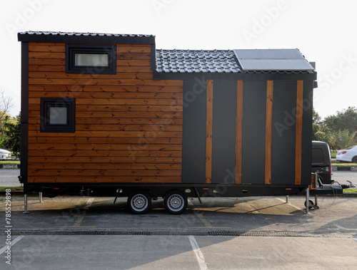 Mobile tiny house, great for outdoor experiences and holidays.  mobility and pure adventure. construction of a mini house. relocated on city. House on wheels. motor home. caravan. solar panels on roof photo