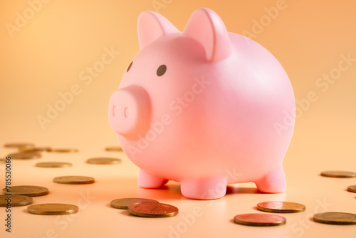 Pink piggy bank overflowing with coins, a popular way to save money