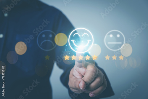 Customer feedback evaluation and satisfaction concept. Businessman touching to five golden stars with smile face icon to the best feedback after use get service.