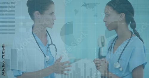 Image of data processing over diverse female doctor and health worker discussing at hospital