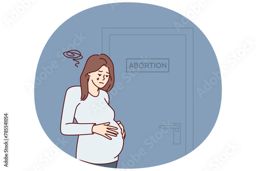 Upset pregnant woman stands near door with abortion sign needs psychologist after making difficult decision. Girl crying wants to terminate pregnancy due to unwanted insemination