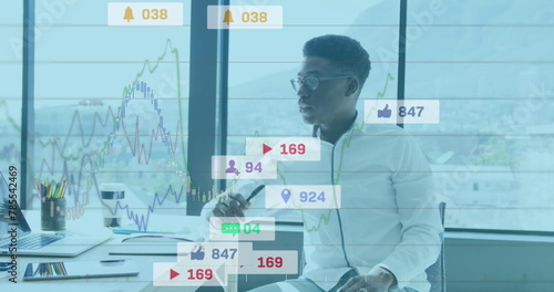Image of notification bars and graphs over thoughtful african american man sitting in office