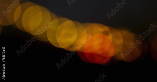 Image of moving spots of yellow light on black background 4k