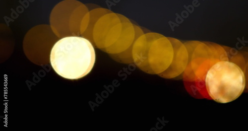 Image of moving spots of yellow light on black background 4k