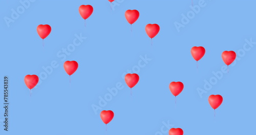 Digital image of multiple red heart shaped balloons floating against blue background
