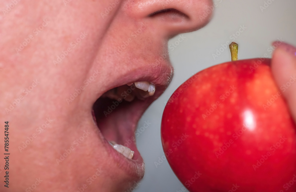 Closeup of a woman's mouth trying to bite an apple. Closeup of a woman's mouth trying to bite an apple.