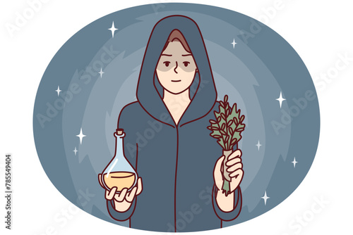 Woman sorceress dressed in cloak with hood holds miraculous elixir and sprig of plant. Healer girl prepared for mysterious rite using magic or healing conspiracy