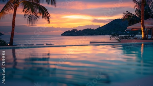 Blurred view of a luxurious hotel pool overlooking a paradisiacal beach at sunset with no one in the image 01