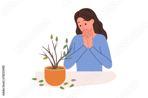 Dried out houseplant in pot causes stress to upset woman who is interested in botany. Discouraged girl sees sick houseplant that has become victim of pests or low-quality fertilizers