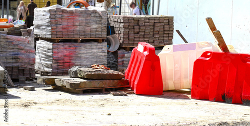 Materials for the repair of water pipes were collected on the square. Plastic large orange pipes, concrete circles and cobblestones and temporary blocks to restrict traffic. repair.