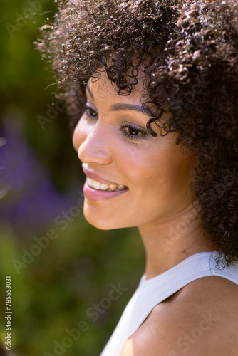 Biracial young woman smiling, standing outdoors at home