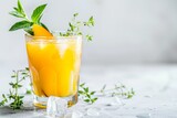 Glass of orange juice with ice, mint leaves on table