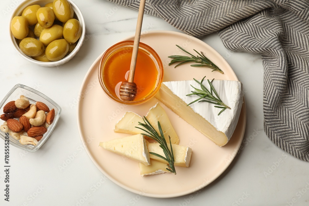 Obraz premium Tasty Camembert cheese with rosemary and honey on white table, flat lay