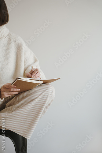 Artist work, business concept. Person writing notes in notebook sitting over white wall. Girl, lady boss