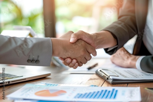 Two business people shaking hands over an office desk, closeup of handshakes and professional attire The concept symbolizes trust Generative AI