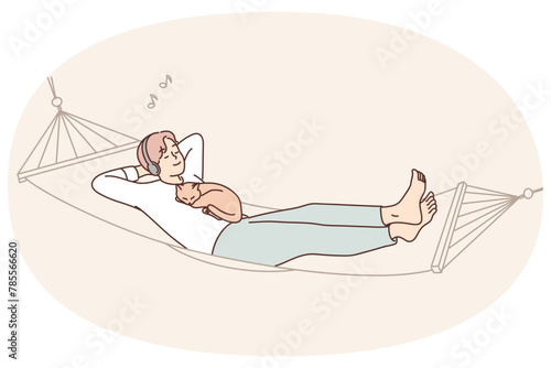 Guy lying with cat in hammock listen to music