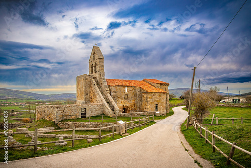 iglesia romanica junto a ruinas romanas en Retortillo Cantabria en una puesta de sol photo