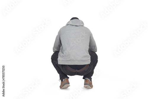 back view of man squatting and looking down on white background