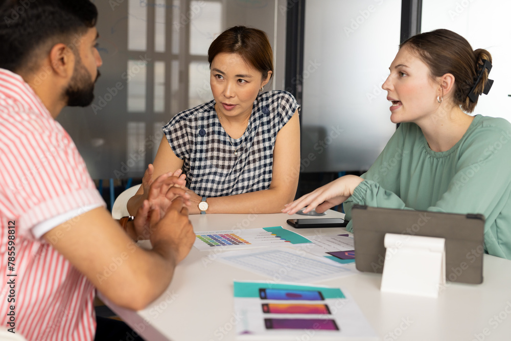 Diverse team discussing app design in a modern business office, mature Asian woman guiding Diverse team discussing app design in a modern business office, mature Asian woman guiding