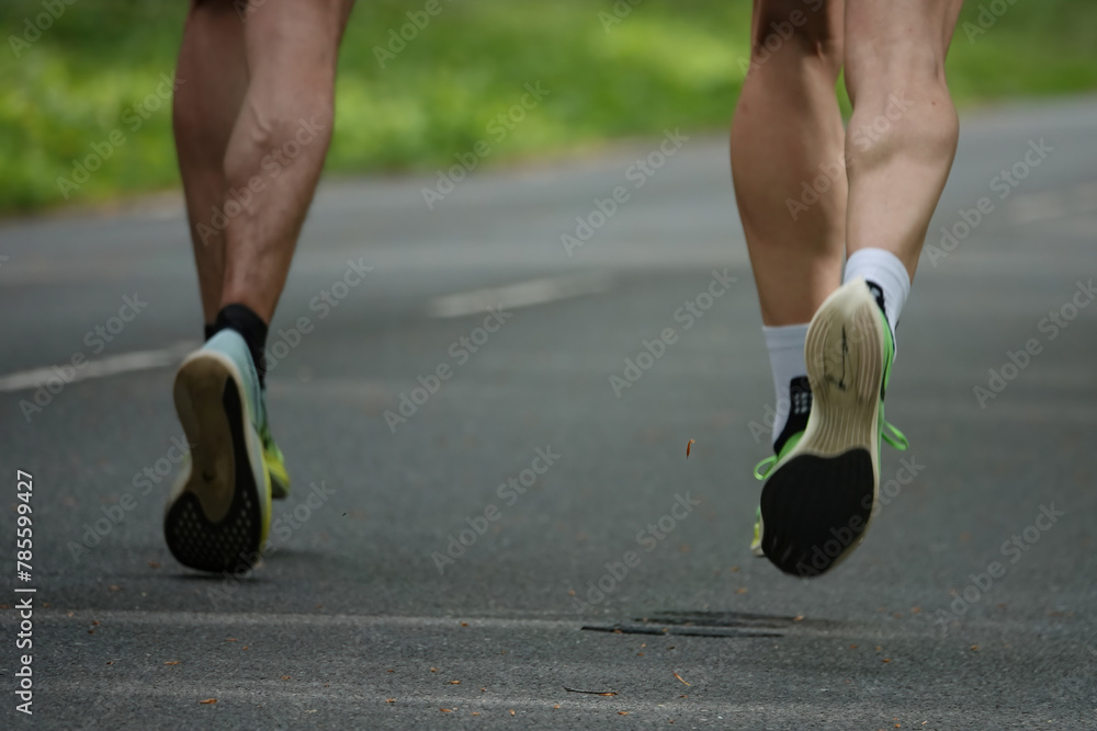 Motion blur of two runners muscular legs and sport shoes