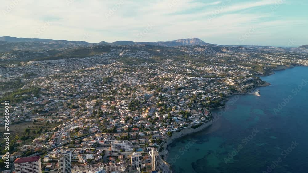 Aerial view of Calp. View of luxury urbanisation build on the hills. Sunset point, with beautiful warm colours reflecting on landscape and buildings. Famous travel destination. Drone tracking right Aerial view of Calp. View of luxury urbanisation build on the hills. Sunset point, with beautiful warm colours reflecting on landscape and buildings. Famous travel destination. Drone tracking right