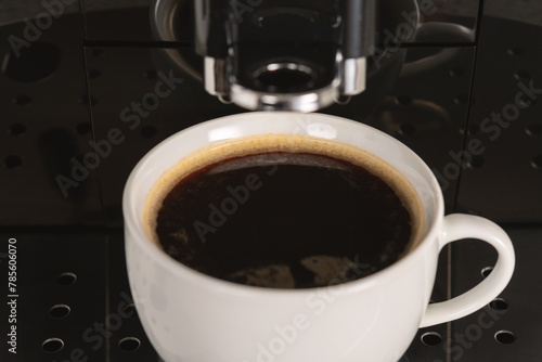Modern espresso coffee machine with a cup closeup.