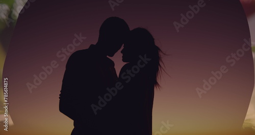 Image of couple embracing over sunset