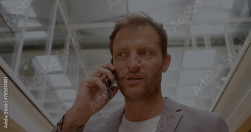 Image of stock market data processing over caucasian businessman talking on smartphone