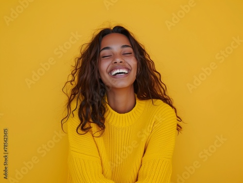 Portrait of happy young woman smiling at camera isolated on bright yellow background