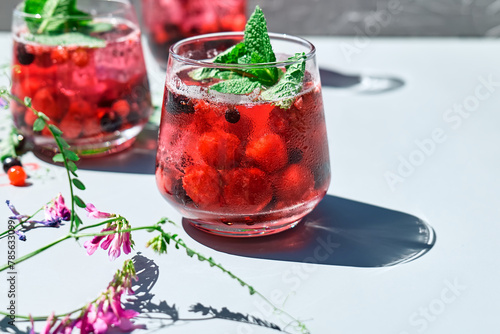 Berry refreshing cold summer drink. Cocktail or mocktail with ripe seasonal berries and mint. Detox drink. Fruit iced thirst quenching drink.