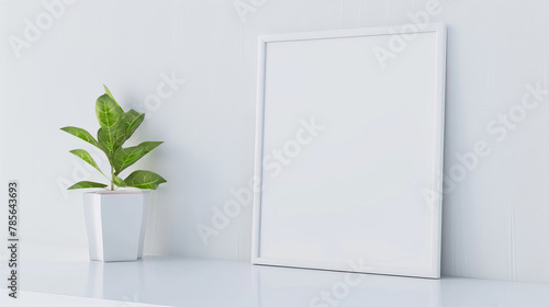 White empty frame on a white wall background next to a plant 