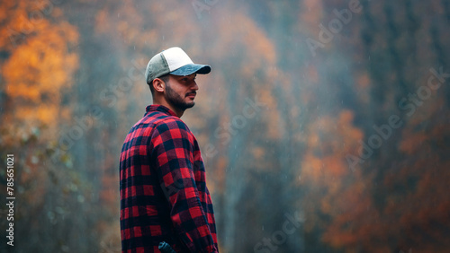 Handsome Lumberjack in Red Checkered Shirt with Axe in Autumn Foggy Forest