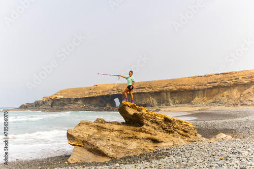 Woman Hiking and Posing on Coastal Rock in Fuerteventura photo
