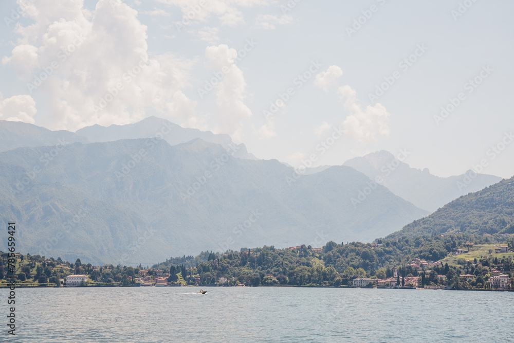 Boat on Lake Como, Italy, mountains and greenery on the background.