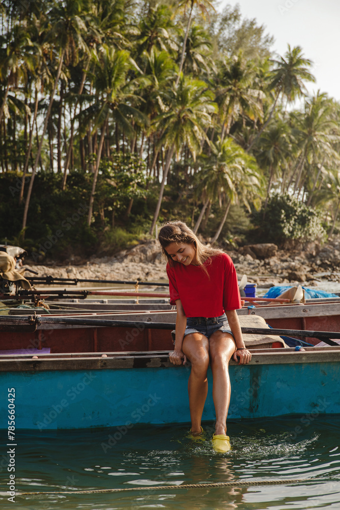 Woman enjoys a quiet moment seated on the edge of a fishing boat