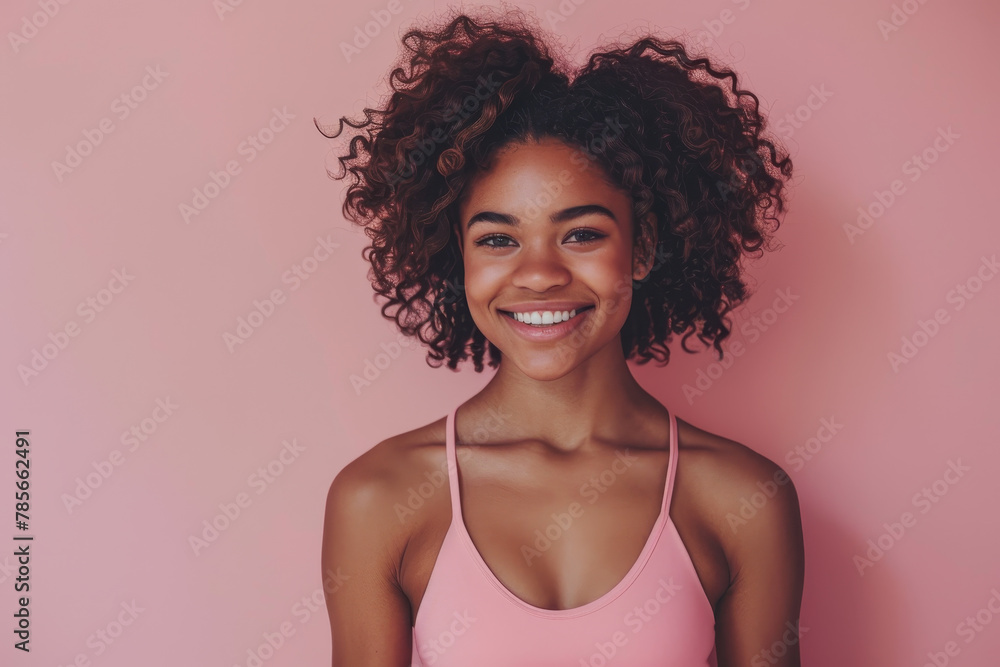 A woman with curly hair is smiling and wearing a pink tank top. The pink color of the tank top and the pink background create a cheerful and vibrant mood A woman with curly hair is smiling and wearing a pink tank top. The pink color of the tank top and the pink background create a cheerful and vibrant mood