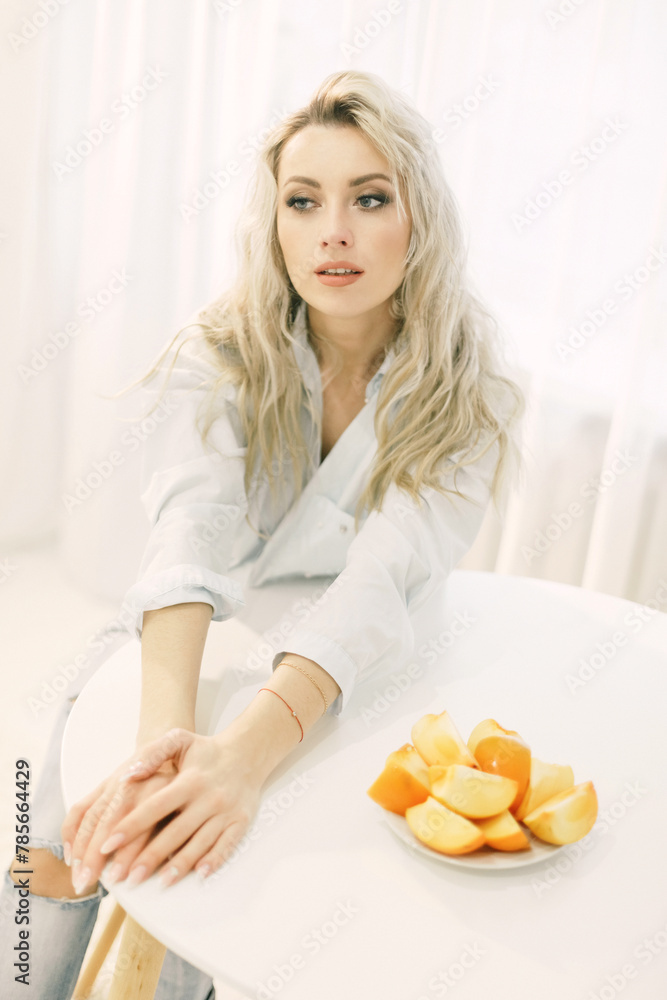 Woman sitting at a table with a plate of persimmons