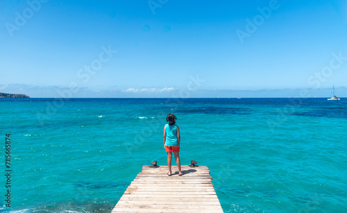 Boy looking at the sea in summer