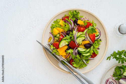 Plate of fresh salad with vegetables on white rustic background