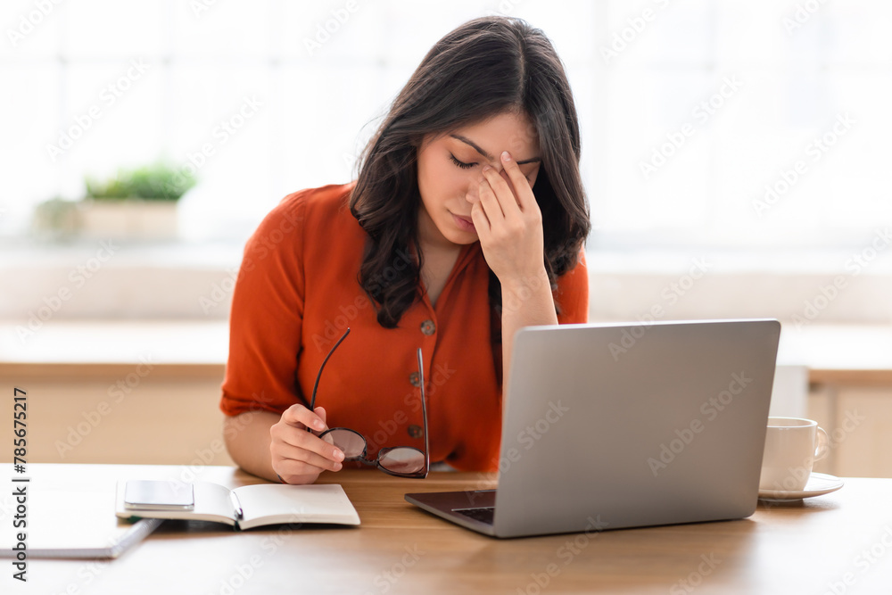 Woman working on laptop at wooden desk Woman working on laptop at wooden desk