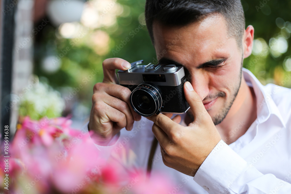 a young man takes photos in the city with his antique photo camera a young man takes photos in the city with his antique photo camera