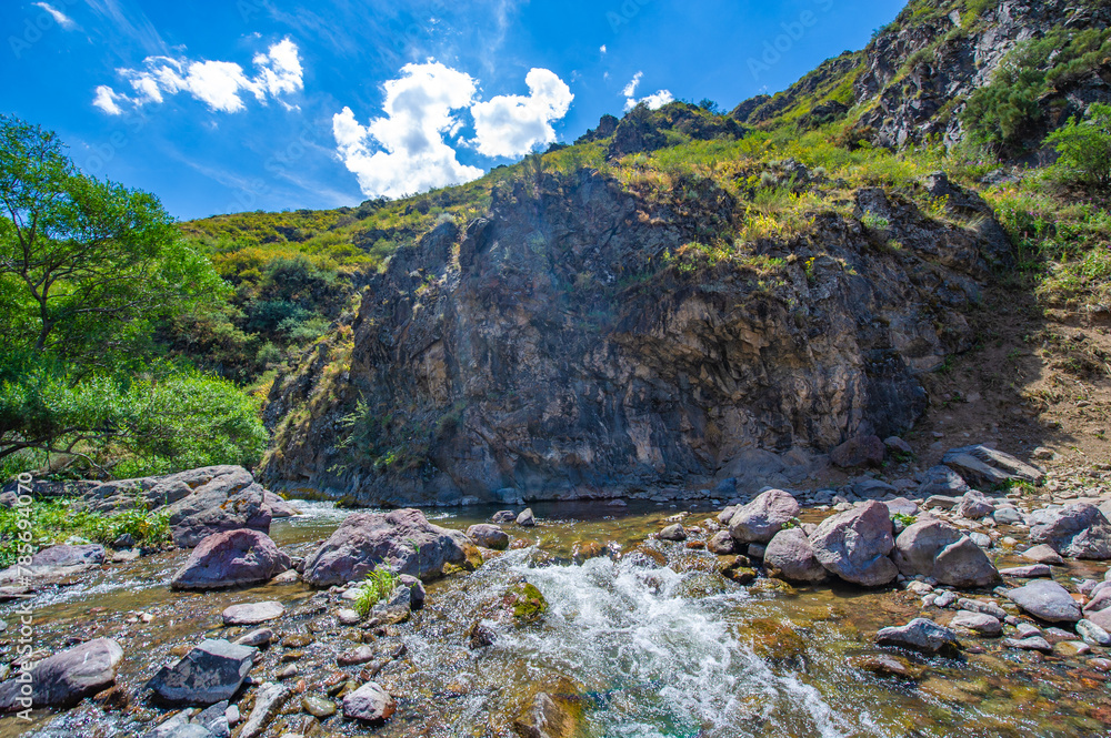 Experience the serene beauty of nature in a rocky canyon. Feel the calming presence of a flowing river amidst the rocky terrain. Immerse yourself in the tranquility of the mountain desert.