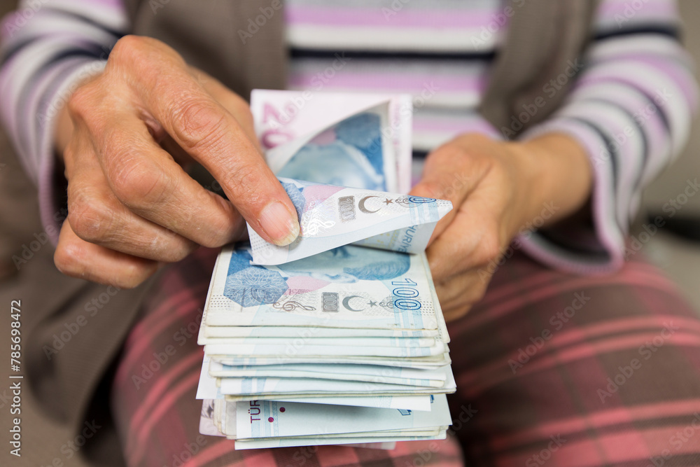 Closeup of wrinkled hands holding turkish lira banknotes Closeup of wrinkled hands holding turkish lira banknotes
