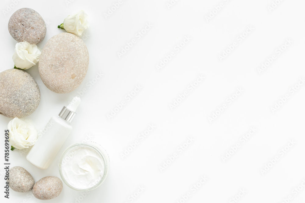 Blank white bottles of skin care cosmetics with roses
